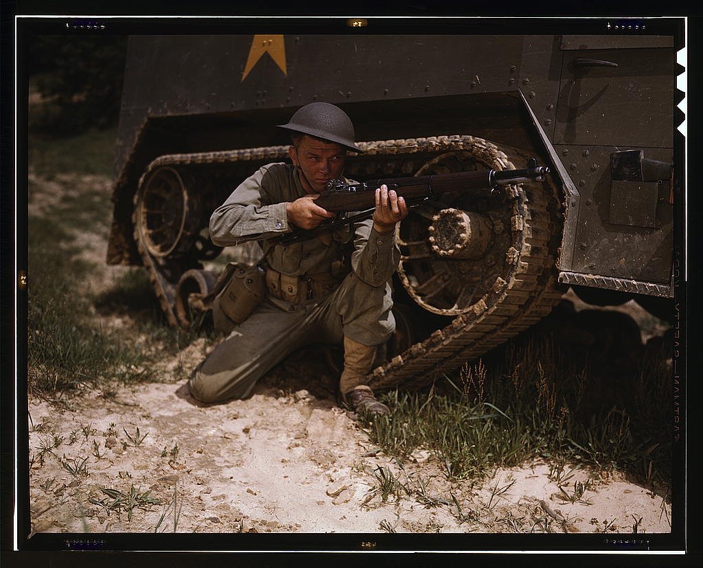 a young soldier of the armored forces holds and sights his garand rifle at fort knox