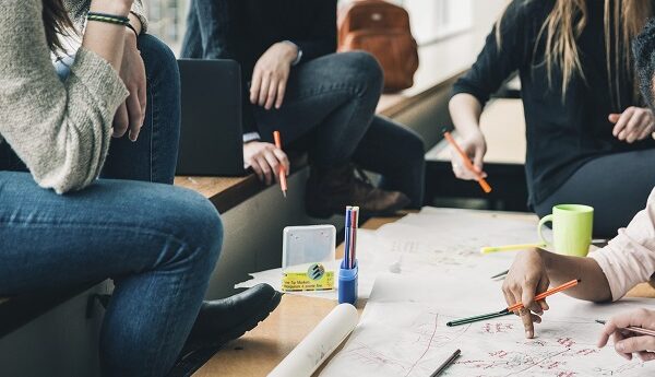 Close up of students around a table working a project, free public domain CC0 photo.